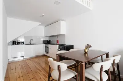 a kitchen with a wooden table and chairs at Panorama Apartments Santa Catharina Porto in Porto