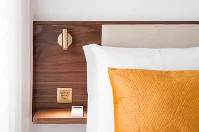a bed with a orange pillow and a wooden headboard at Panorama Apartments Santa Catharina Porto in Porto