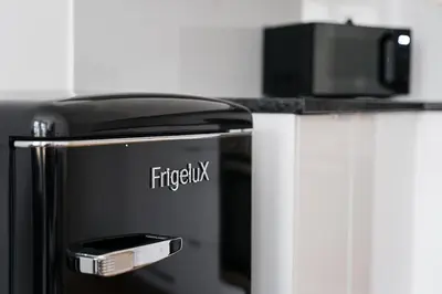 a black refrigerator with a cell phone on top of it at Panorama Apartments Santa Catharina Porto in Porto