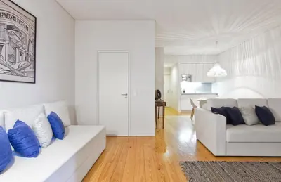 a white bedroom with a bed and a window at Casas do Rivoli in Porto