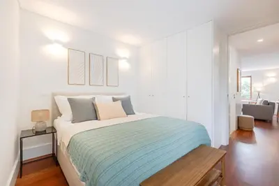 a white bedroom with a large bed and a table at Balcony Retreat | Porto Urban Flats in Porto