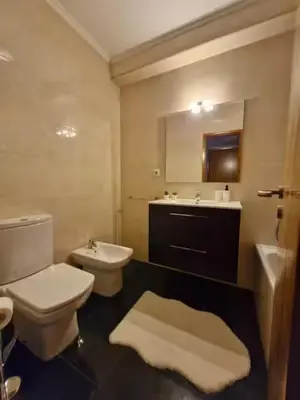 a bathroom with a toilet and a sink and a mirror at Oliveira Charm-Porto in Porto