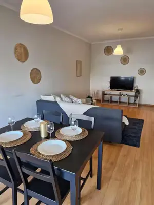 a living room with a table and chairs and a couch at Oliveira Charm-Porto in Porto