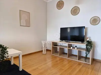 a living room with a flat screen tv on a table at Oliveira Charm-Porto in Porto