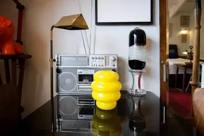 a room with a radio and a lamp with a stack ofools at Caligrafia - Artistic Studio in Porto