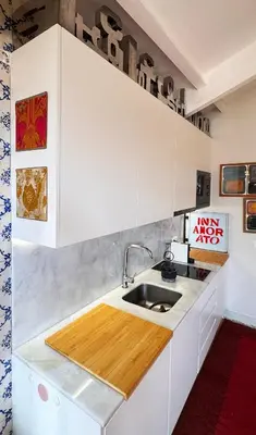 a kitchen with white cabinets and a sink at Caligrafia - Artistic Studio in Porto