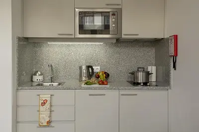 a kitchen with white cabinets and a microwave at Clerigos View in Porto