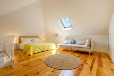a bedroom with a bed and a couch and a window at Porto Santo Ildefonso Central Loft in Porto