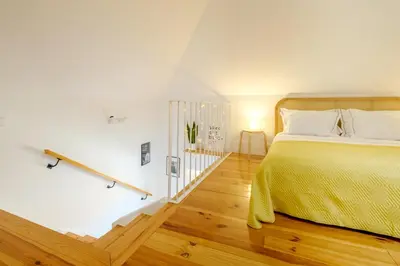 a bedroom with a large bed and wooden floors at Porto Santo Ildefonso Central Loft in Porto
