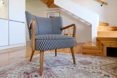 a chair in a room with a rug at Porto Santo Ildefonso Central Loft in Porto