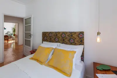 a bedroom with a bed with two yellow pillows at Aida's Haven - Bolhão in Porto