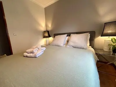 a bedroom with a large white bed with two lamps at Douro Exclusive View in Vila Nova de Gaia