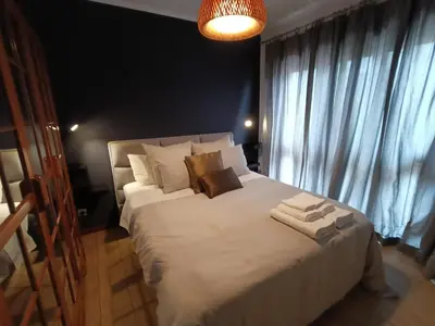 a bedroom with a large white bed with towels on it at Douro Exclusive View in Vila Nova de Gaia