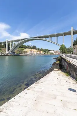 a person riding a bike on a bridge over the water at Gaia Land Sea View Apartment in Vila Nova de Gaia