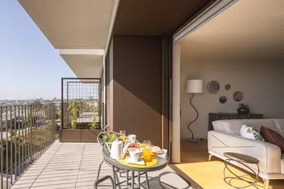 a room with a balcony with a table and a couch at Gaia Land Sea View Apartment in Vila Nova de Gaia