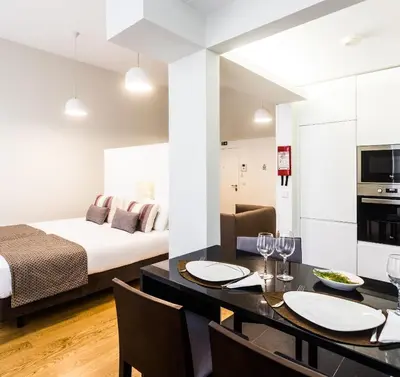 a room with a bed and a dining room with a table at Oportolazaro Premium Downtown Porto in Porto