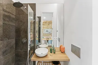 a white bathroom with a sink and a shower at GuestReady - Relaxing Porto stay in Porto