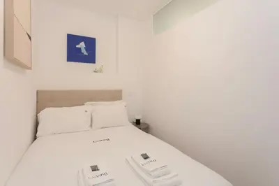 a bedroom with a white bed with two phones on it at Liiiving in Porto - Invictus Bolhao Market in Porto