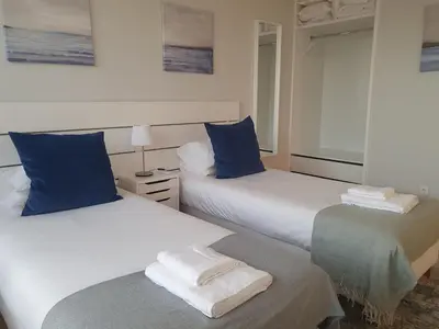 two beds with blue pillows in a bedroom at Charming Apartment in the Heart of Historic Porto in Porto