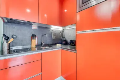 a red kitchen with a sink and red cabinets at Ribeira Dreams in Porto