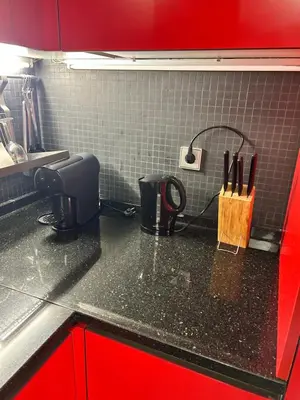 a kitchen with red cabinets and a black counter top at Ribeira Dreams in Porto