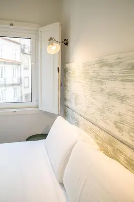 a bedroom with a white bed and a window at Oporto Riverside Rooftop in Porto