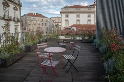 a patio with tables and chairs on a balcony at Oporto Riverside Rooftop in Porto