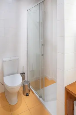 a bathroom with a toilet and a glass shower at Oporto Riverside Rooftop in Porto