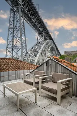 two benches and a table in front of a bridge at GuestReady - Douro Nest Apartments in Vila Nova de Gaia