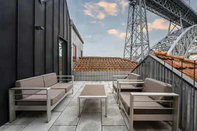 a balcony with chairs and tables on a building at GuestReady - Douro Nest Apartments in Vila Nova de Gaia