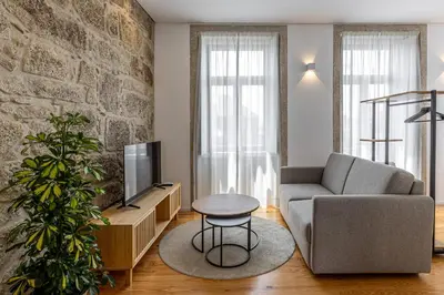 a living room with a couch and a tv at Filigrana Apartments in Porto