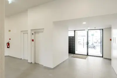 a room with white walls and a hallway with doors at VIVA Central Downtown Studio in Porto