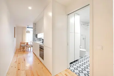 a kitchen with white cabinets and a toilet in a room at VIVA Central Downtown Studio in Porto