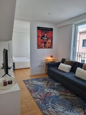 a living room with a blue couch and a rug at Ponte & Morro Apartment in Vila Nova de Gaia