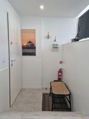 a room with a chair and a television on a wall at Ponte & Morro Apartment in Vila Nova de Gaia