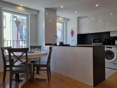 a kitchen and dining room with a table and chairs at Ponte & Morro Apartment in Vila Nova de Gaia