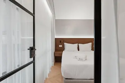 a bedroom with a bed with white sheets and a window at GuestReady - Stylish base steps from attractions in Porto