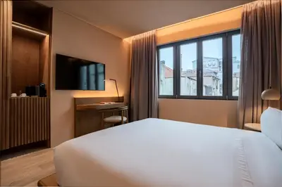 a hotel room with a bed and a large window at Akeah Porto Centro in Porto