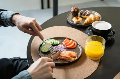 a person eating food on a table with a plate of food at Akeah Porto Centro in Porto