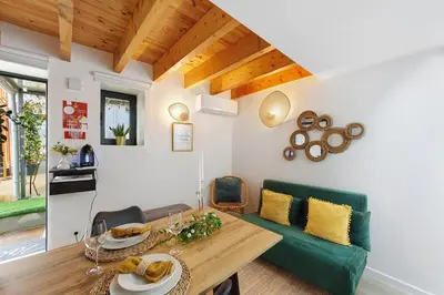 a living room with a green couch and a table at Cantinho da Lapa in Porto