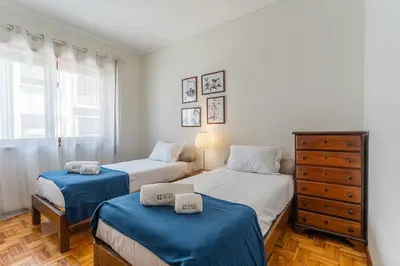 a bedroom with two beds and a dresser in it at GuestReady - Home Comforts in Porto in Porto
