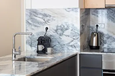 a kitchen with a marble counter top and a sink at Stylish & Cozy 1BR with AC by LovelyStay in Porto