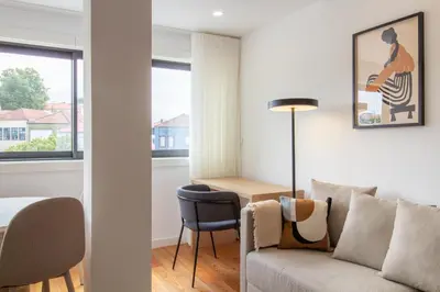 a living room with a couch and a table at Stylish & Cozy 1BR with AC by LovelyStay in Porto