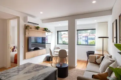 a living room with a couch and a table at Stylish & Cozy 1BR with AC by LovelyStay in Porto