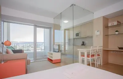 a kitchen and living room with a large glass wall at Oporto Blue Dragão - Modern Uptown Studio With Free Parking in Porto