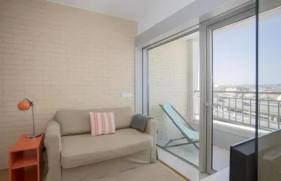 a living room with a couch and a chair at Oporto Blue Dragão - Modern Uptown Studio With Free Parking in Porto