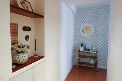 a hallway with a wall with a mirror and a table at Porto Family Home Apartment in Porto