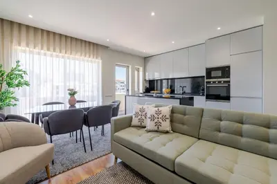 a living room and kitchen with a couch and a table at Central & Stylish Apartment by HostWise in Porto