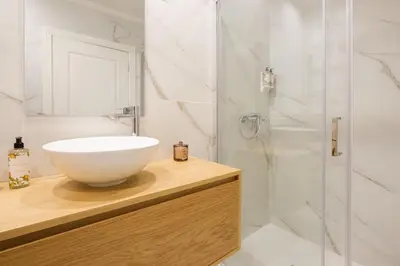 a bathroom with a white sink and a shower at Art Deco 14 Luxury Apartment Downtown Metro AC in Porto