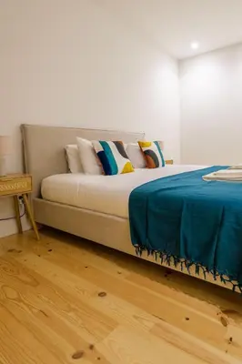 a bed with pillows on it in a room at Art Deco 24 Luxury Apartment Downtown Metro AC in Porto